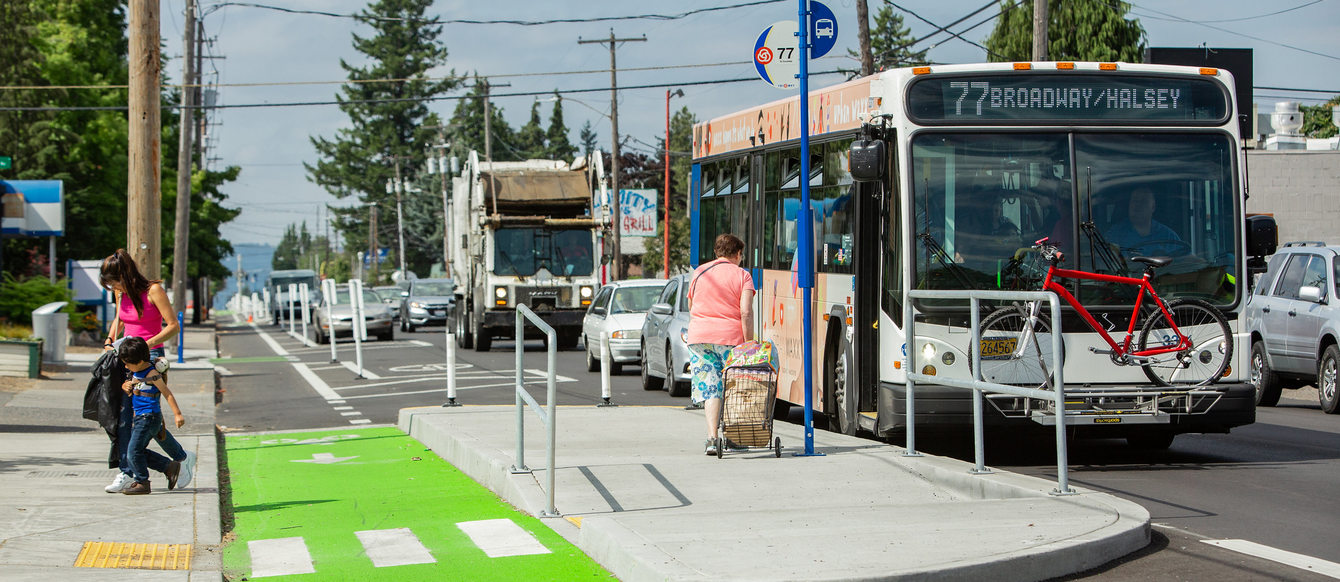 People board and disembark from a TriMet bus on NE Halsey Street.