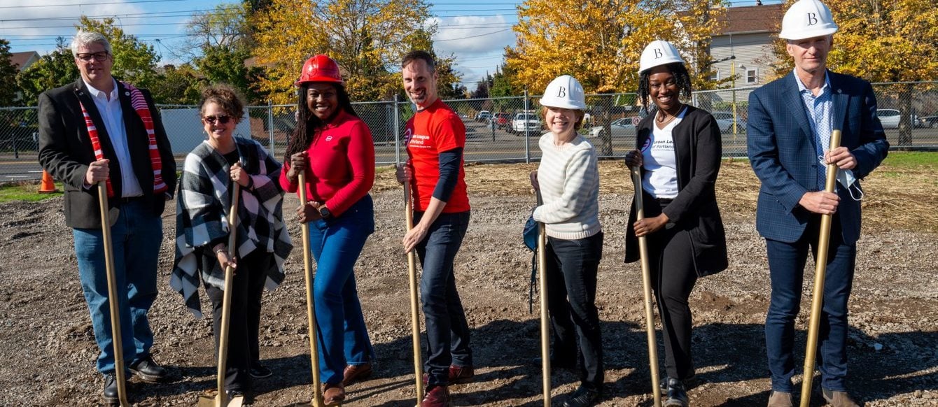Seven people with golden shovels breaking ground 