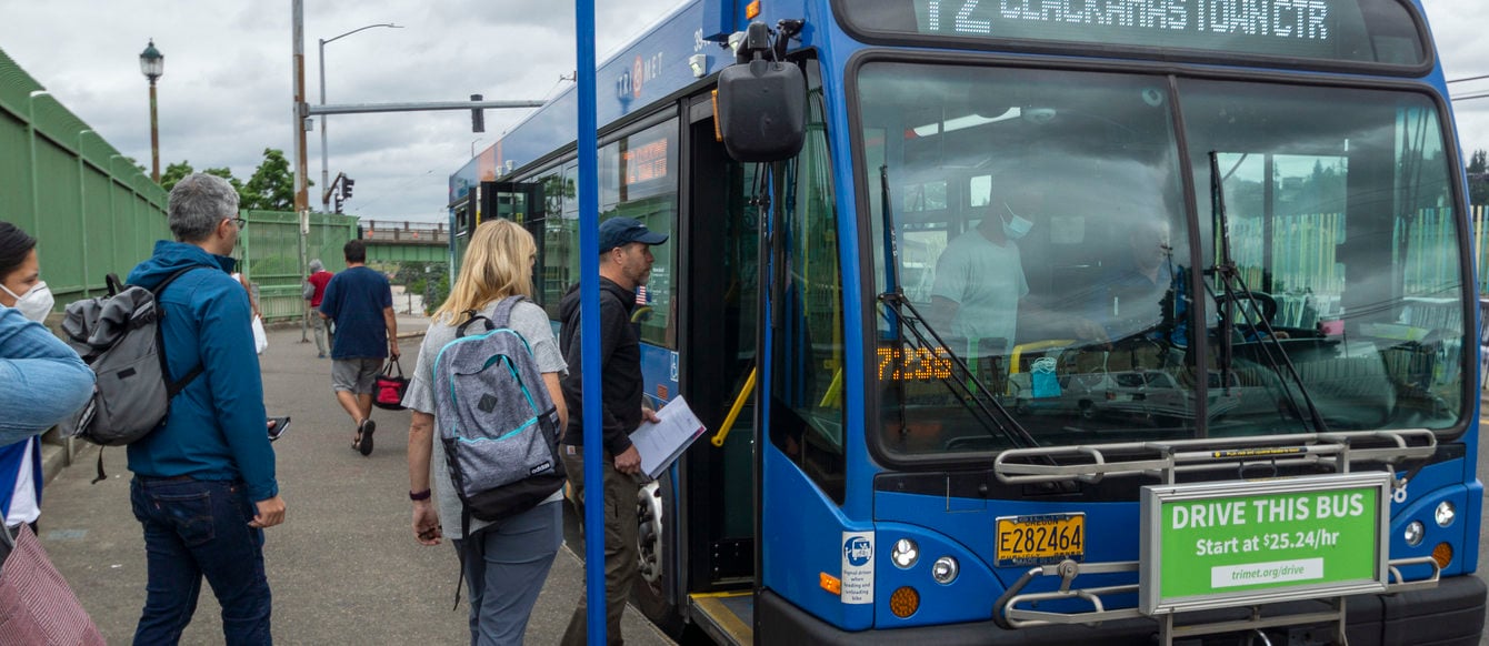 TriMet line 72 at MAX connection bus stop with riders boarding