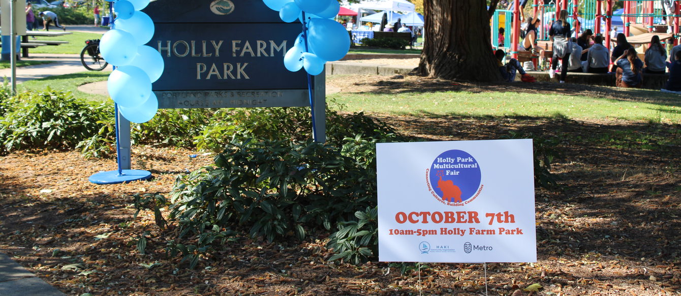 The Holly Farm Park entrance sign with blue balloons and a sign for the multicultural fair on October 7, 2023.