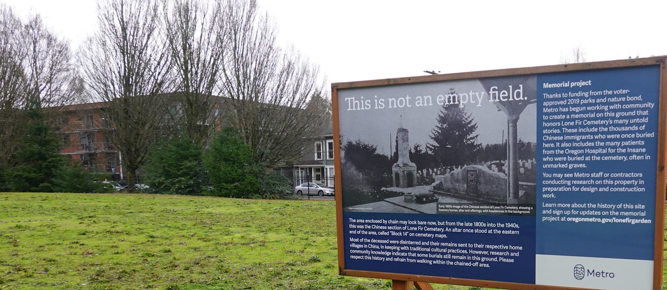 A large sign in a grassy field; the sign has an old photo of a Chinese altar and the words "This is not an empty field"