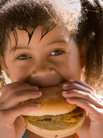 photo of girl eating hamburger