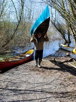 photo of a man putting a canoe in the water at Smith and Bybee