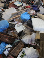 Loads of mixed items including anything from baskets to fire pits to mattresses are unloaded into a giant heap.
