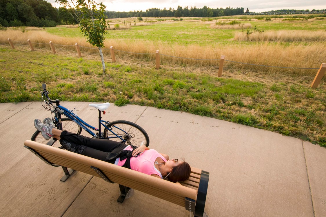 photo of a biker resting on a bench at Graham Oaks