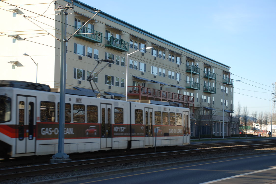 a photo of a large building with a MAX train in the foreground