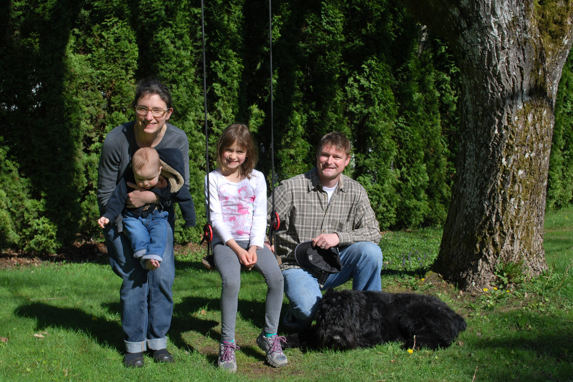 photo of a family and their dog in the garden