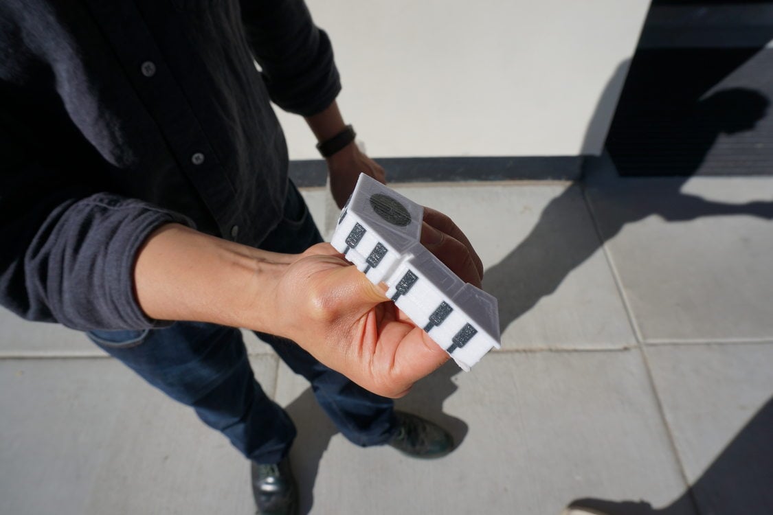 person holding a small scale model of Northwood Apartments