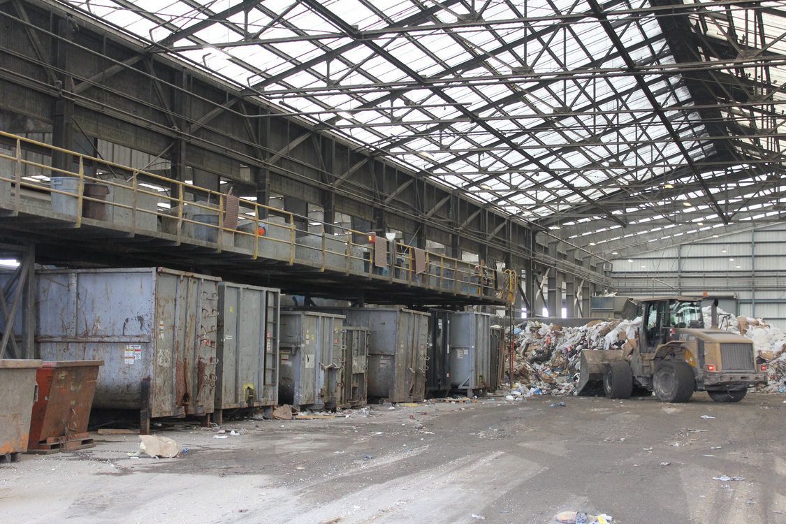 Another view of the sorting line. As workers pull recyclables, they drop them into designated bins below.