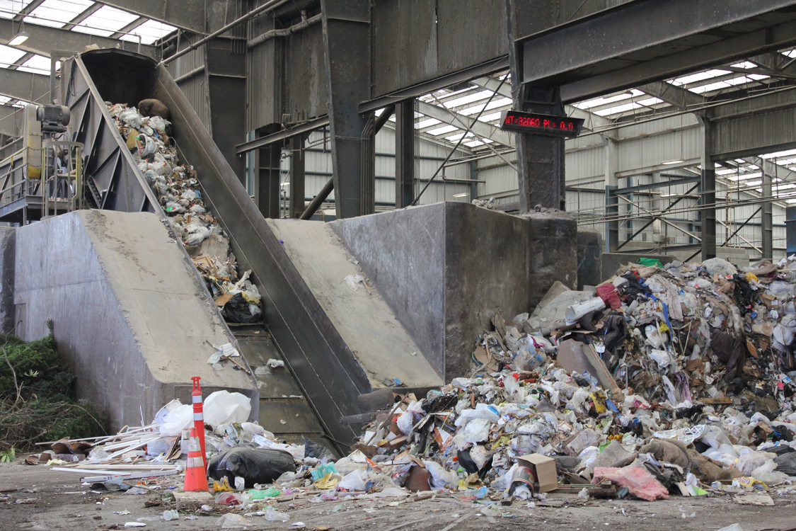 Non-salvageable waste is worked into a pit and up a ramp, where it will be compacted into a semi-truck trailer.