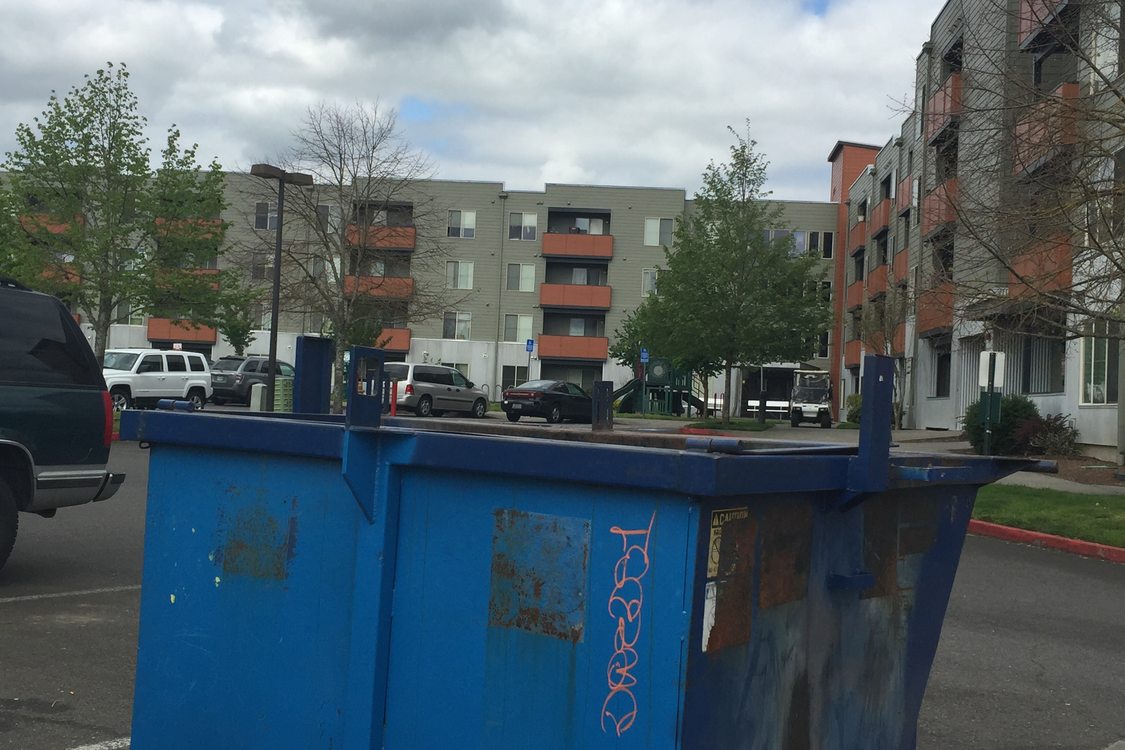 dumpster in parking lot of apartment complex