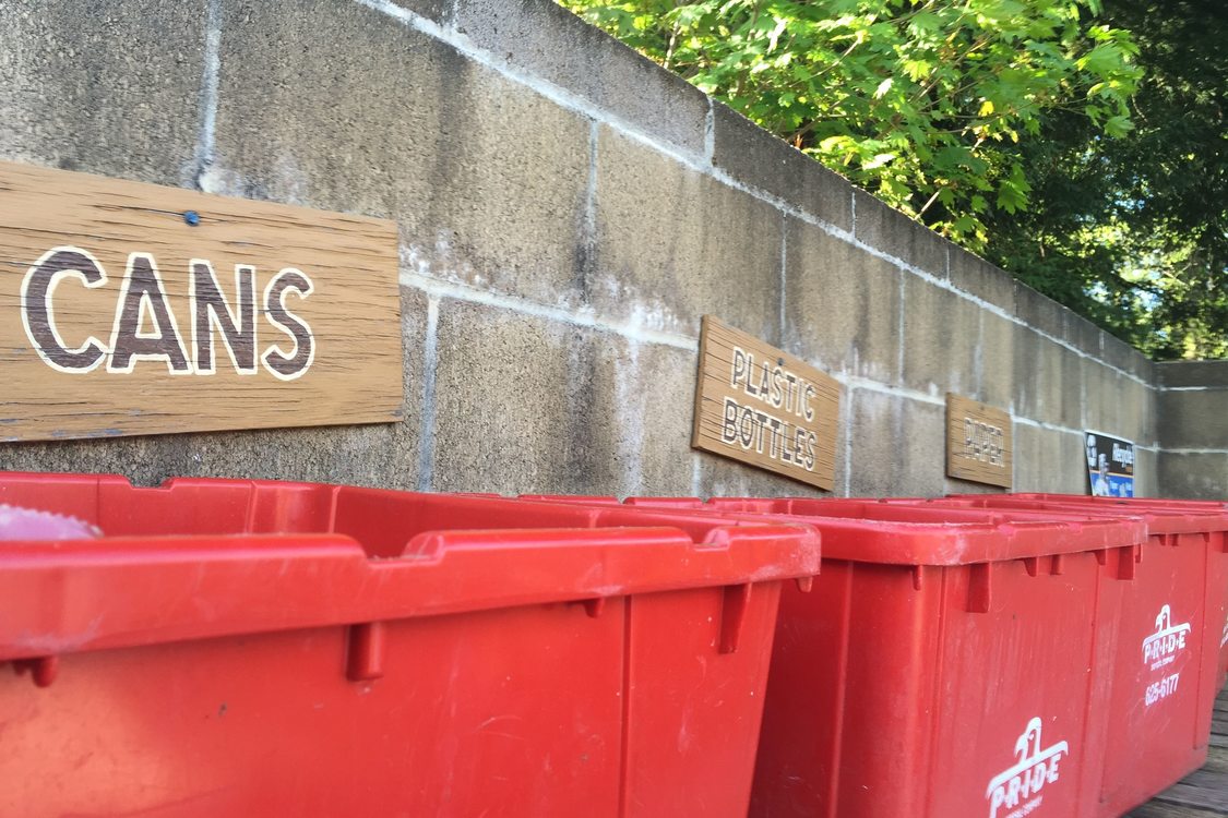 red recycling bins labeled for different materials