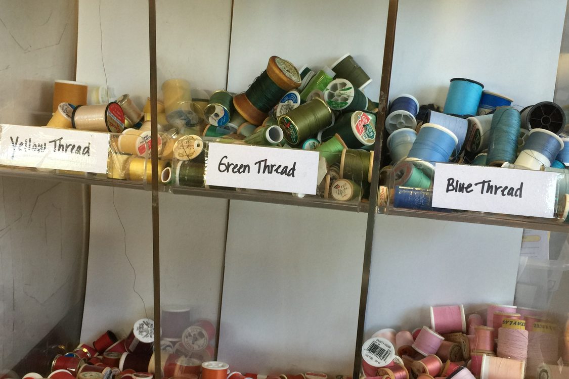 storage bins of used thread sorted by color