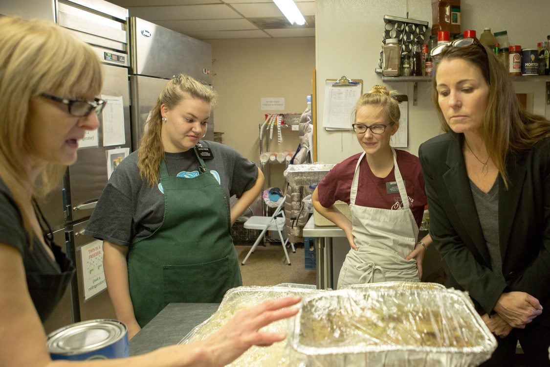 volunteers at Clackamas Service Center have a discussion around a table covered with food