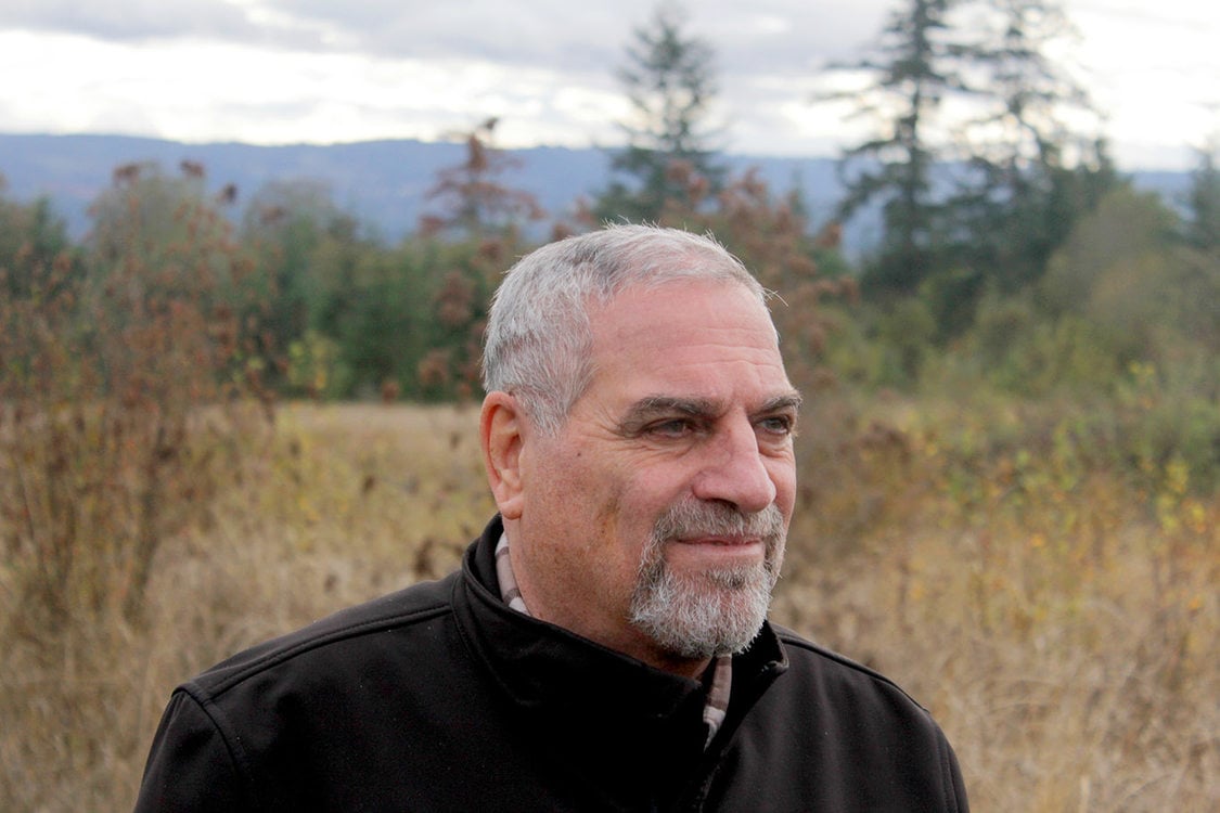 Muwafaq Alkattan stands on a trail at Cooper Mountain Regional Park. A refugee from Iraq, Alkattan 