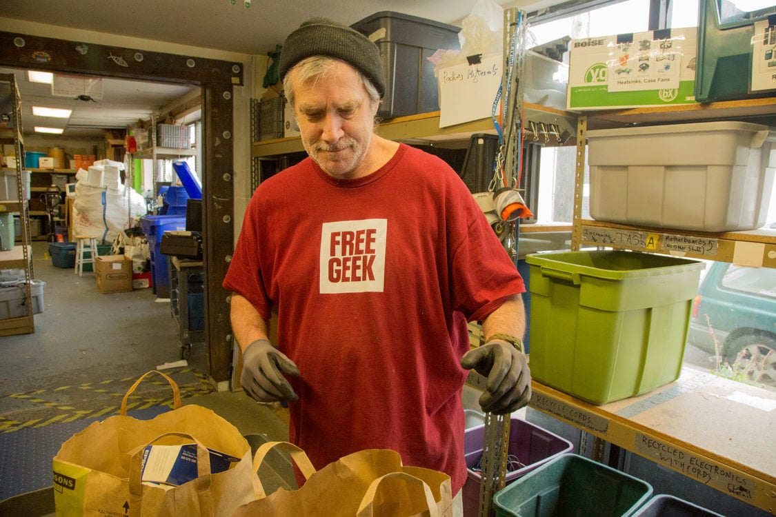 employee of Free Geek sorting through bags of donated electronics