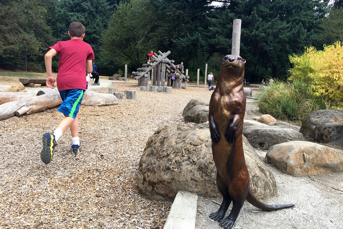 bronze sculpture of an otter and children playing at Nadaka Nature Park