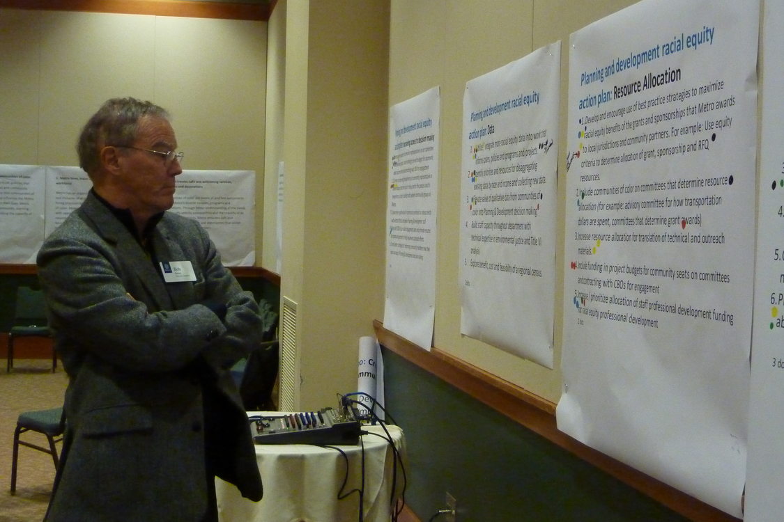 Photo of Metro Councilor Bob Stacey looking at the sheets of paper hung on the wall.