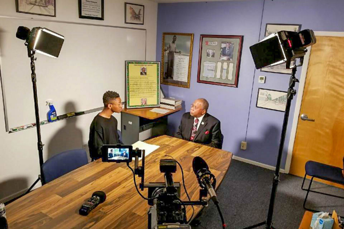 A young man interviews an older man