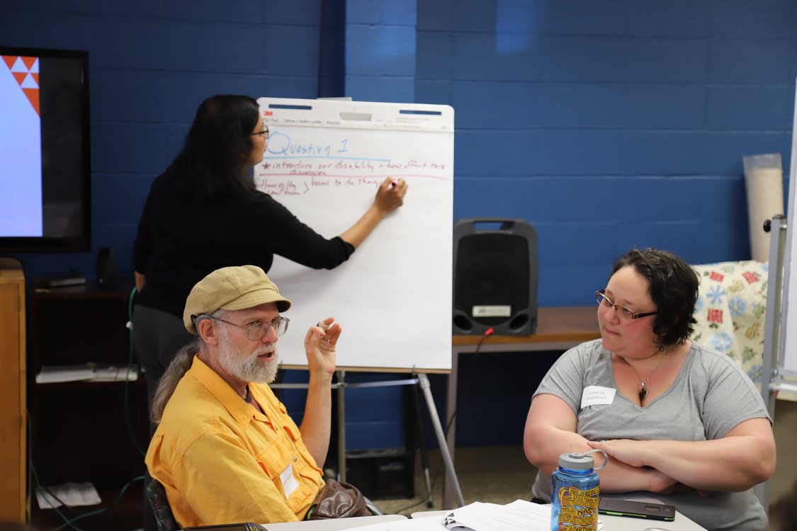 A Metro employee takes notes while disability community members discuss