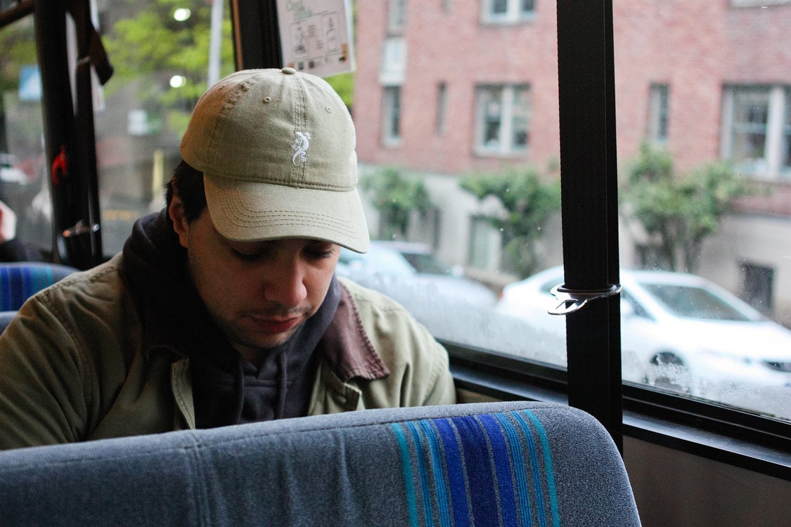 A young man sits on a bus
