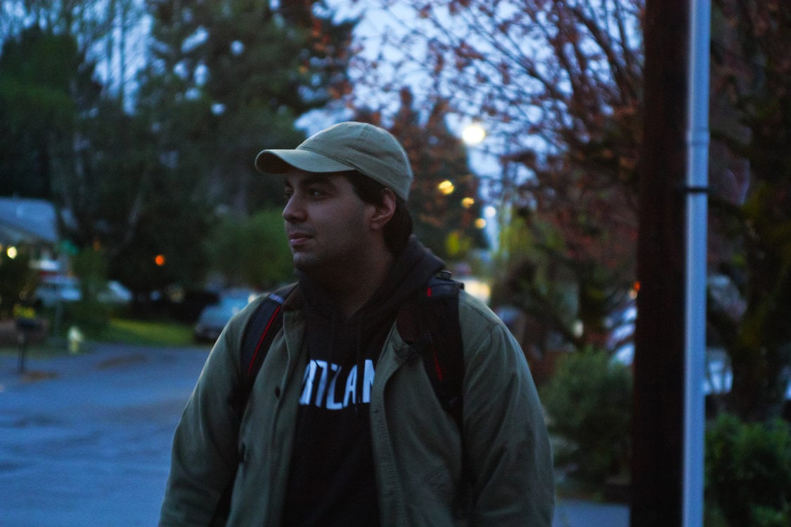 A young man looks to the side in the morning light