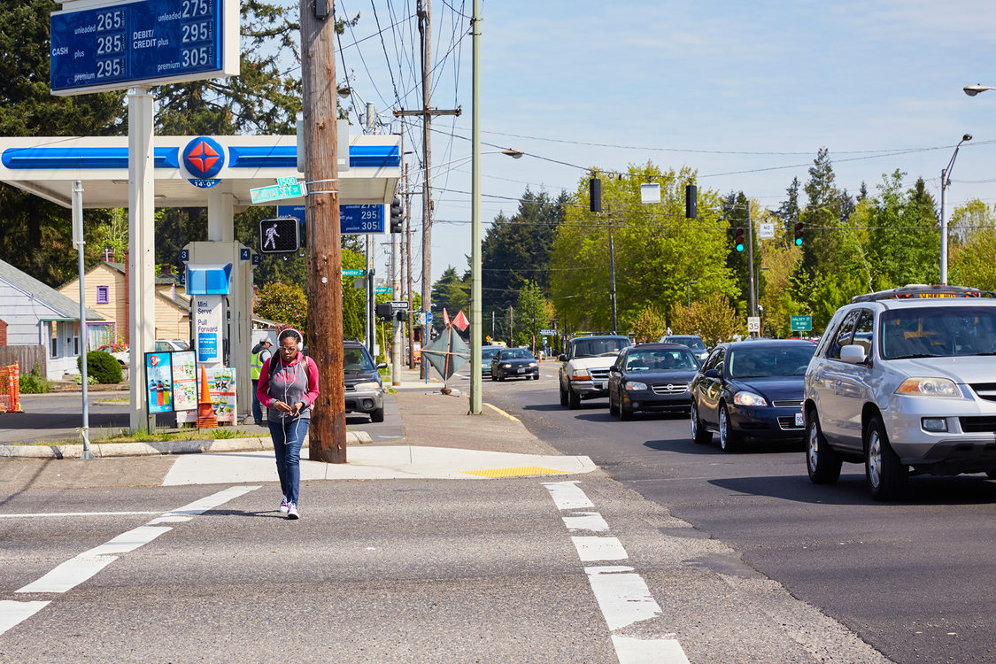 A young woman walks along a busy road