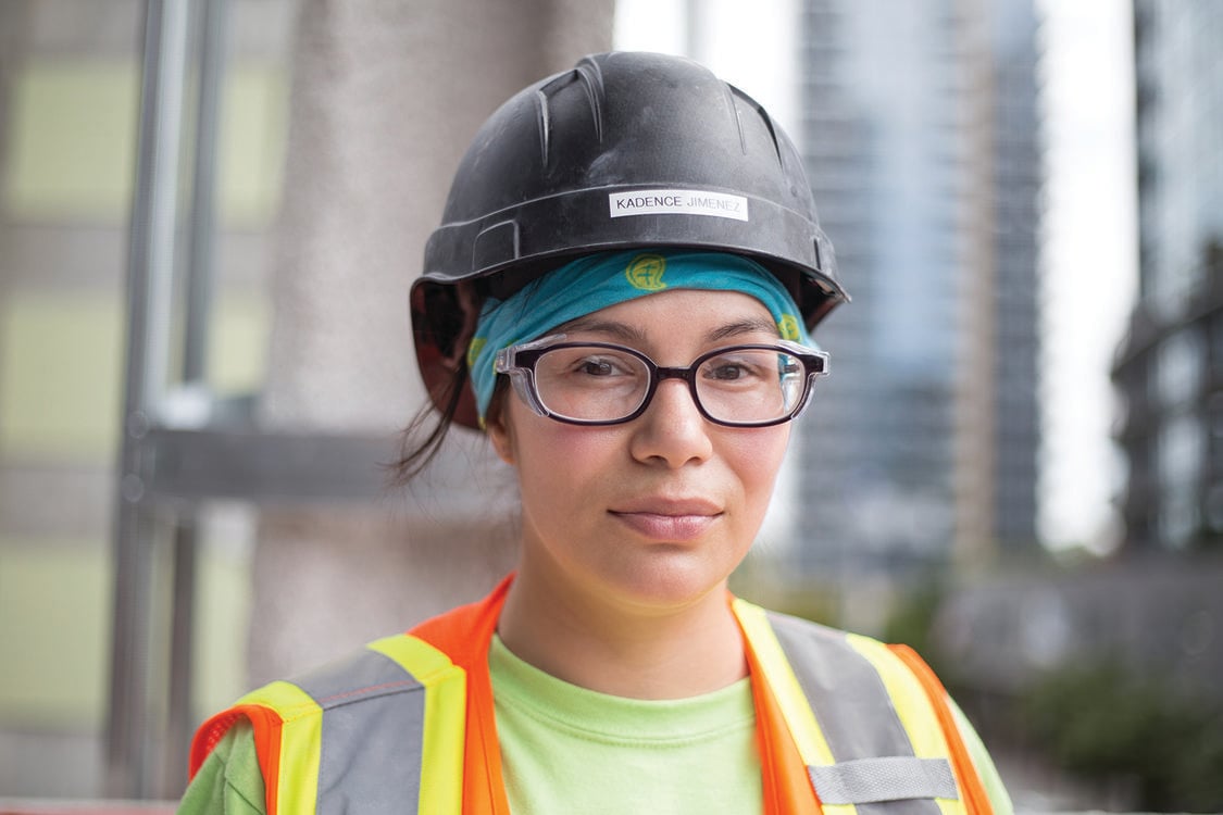 Photo of a woman wearing a hard hat and vest on a construction site