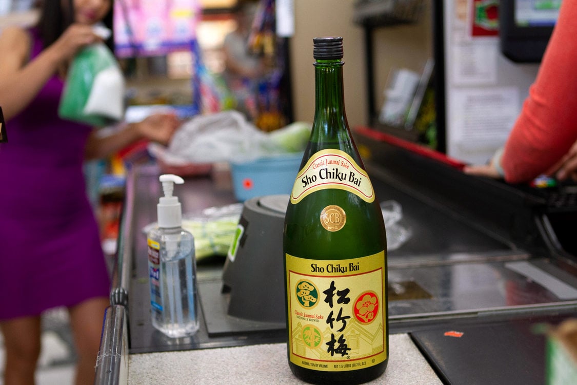 A glass sake bottle gets scanned at a grocery checkout stand