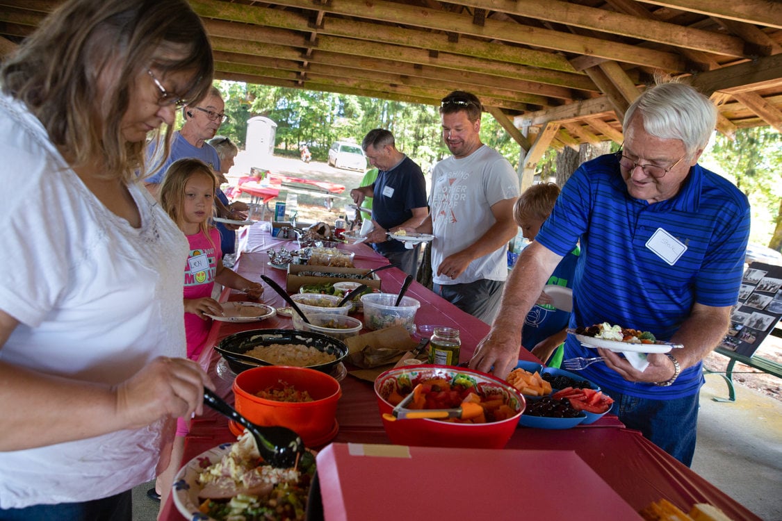 Neighbors filling their plates during a potluck picnic at Mason Hill