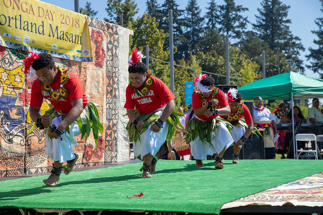 A group of Tongan dancers land from a jump