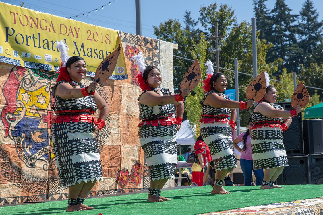 A dance group holds up fans