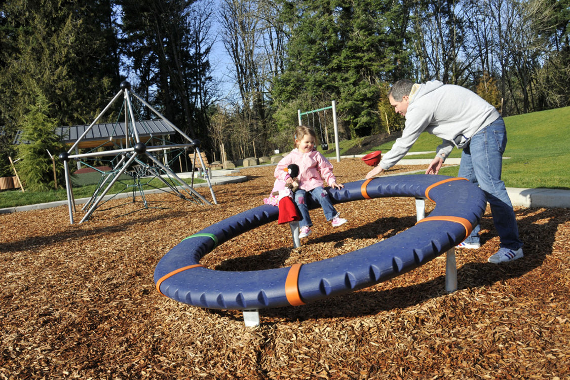 Photo of father and daughter playing on playground