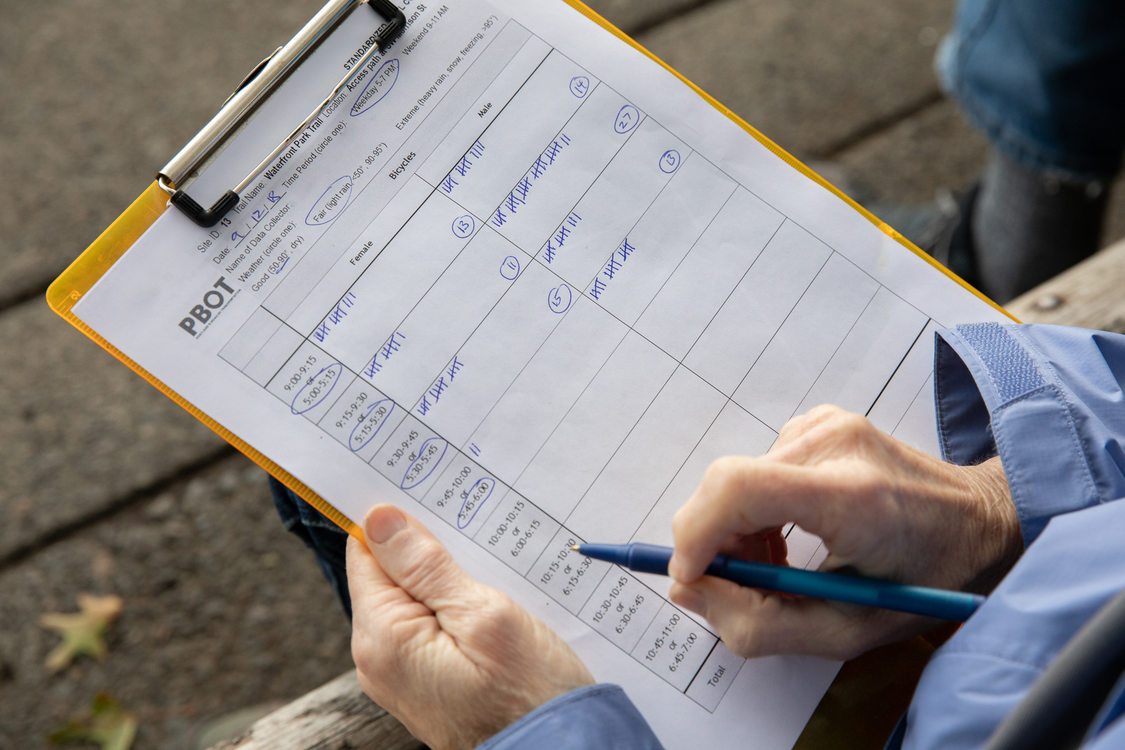 Trail count volunteer holding a PBOT trail count data collection sheet.