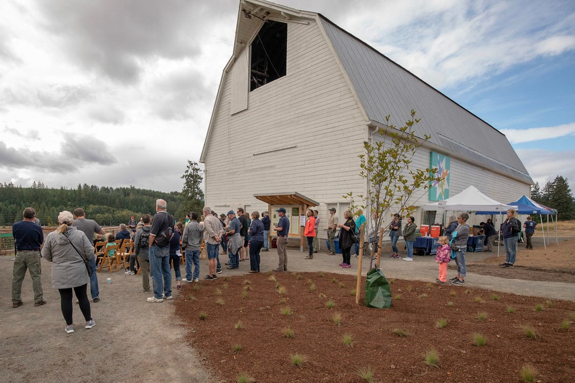 Visitors gather next to a restored dairy barn for the grand opening ceremony of Killin Wetlands Nature Park.
