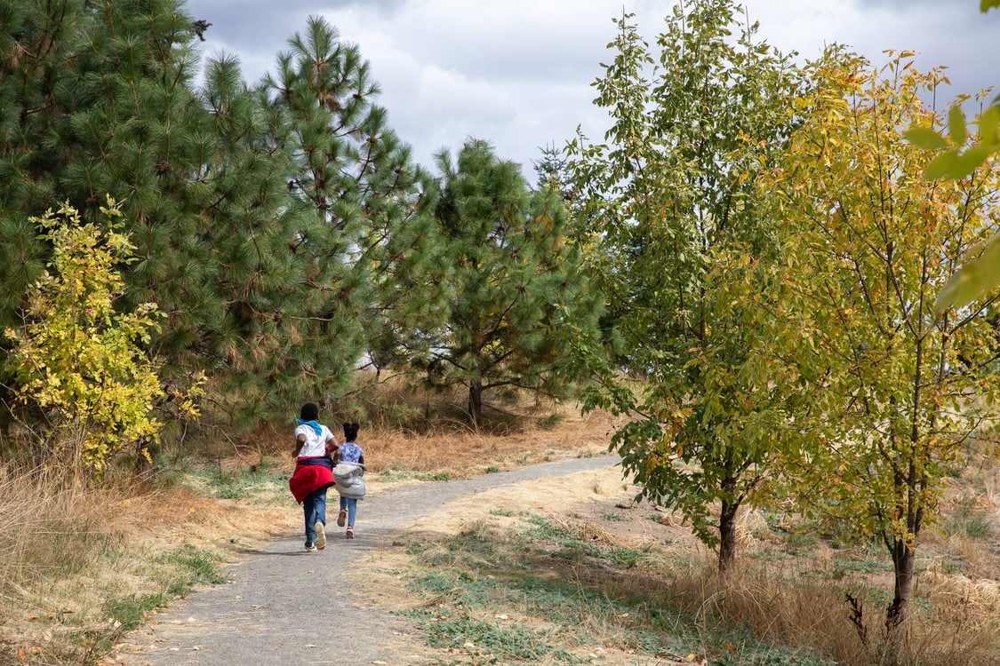 Gary Black,9, chases his sister, Nia Black, on a nature nature trail in Killin Wetlands Nature Park.