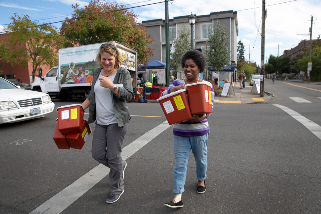 Metro employee helps carry free sharps boxes to a woman's car