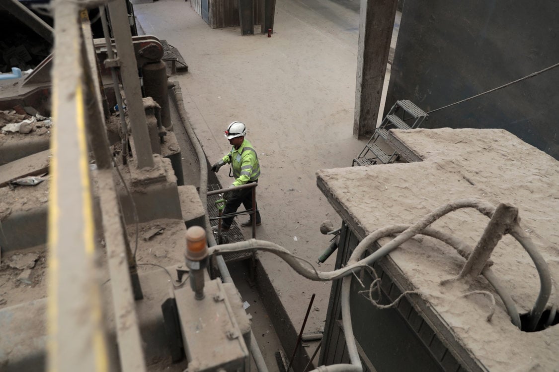 a man in a hard hat closes up a truck trailer fun of trash 