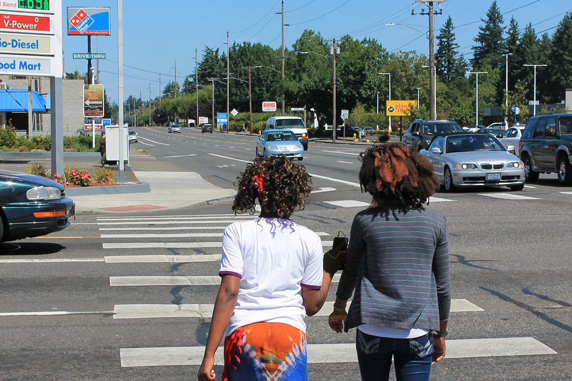 Teens walk across a busy street