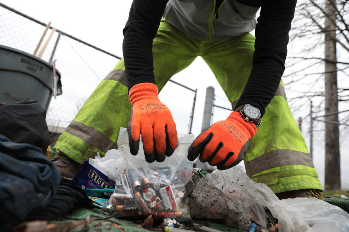 gloved hands put batteries into a ziplock bag