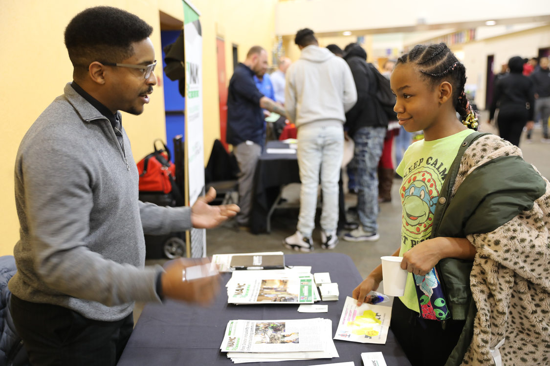 man talks to student at SEI trades fair