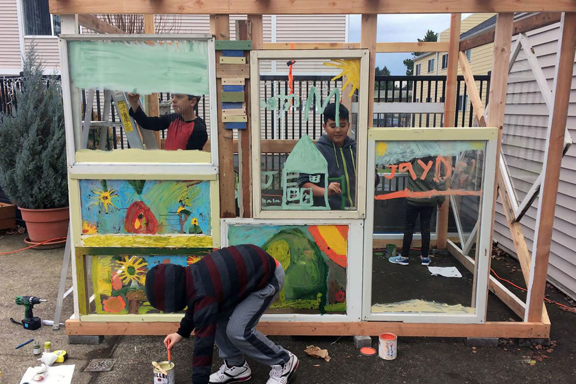 little boys working on an art installation in a backyard