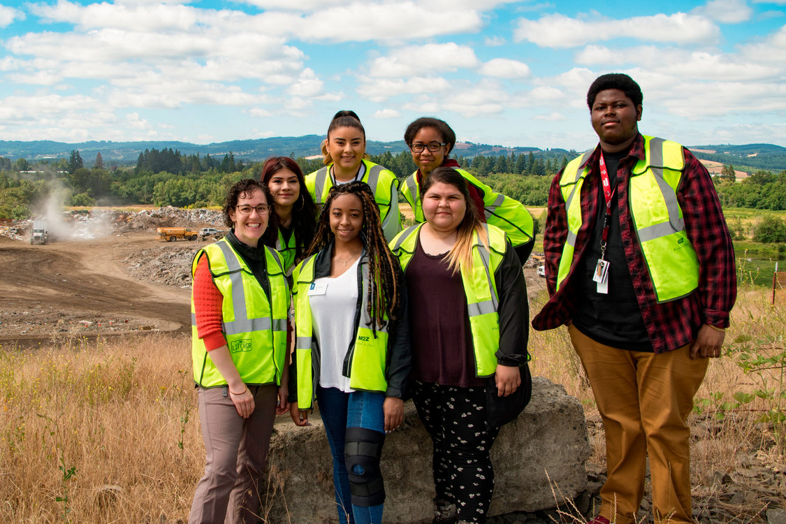 group shot of garbage and recycling interns and staff in neon vests 