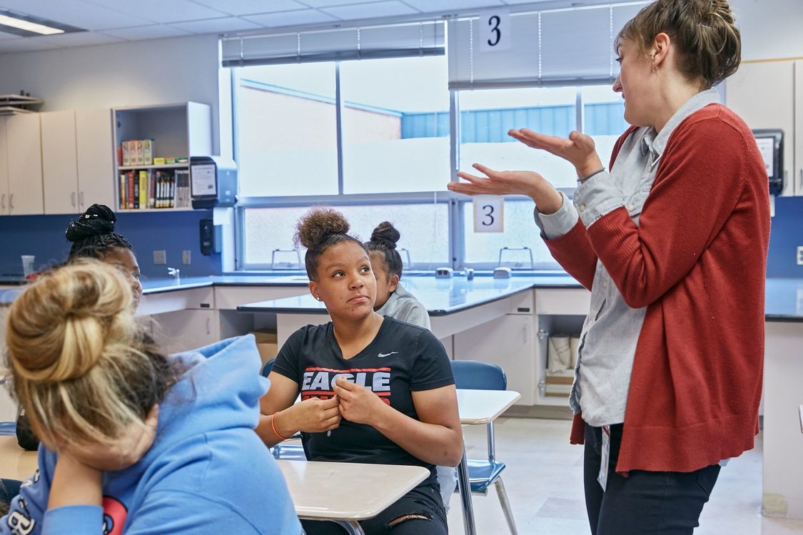 Metro educator talking with student in classroom