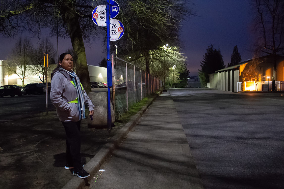 Una mujer espera el autobús en la madrugada.