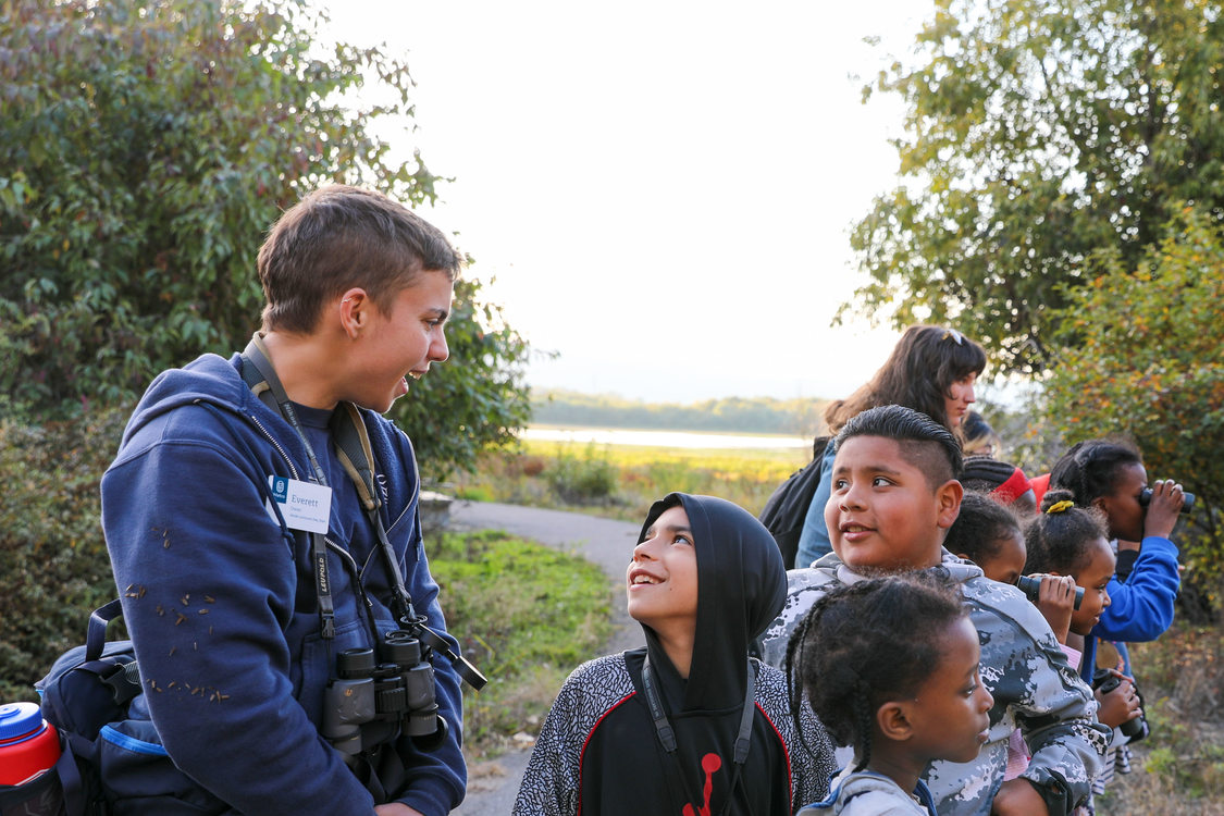 Naturalists speak with students in nature