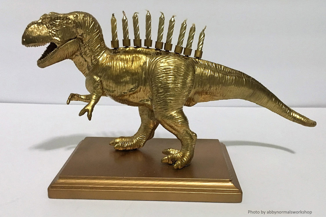 A child's toy dinosaur has been painted gold and turned into a menorah