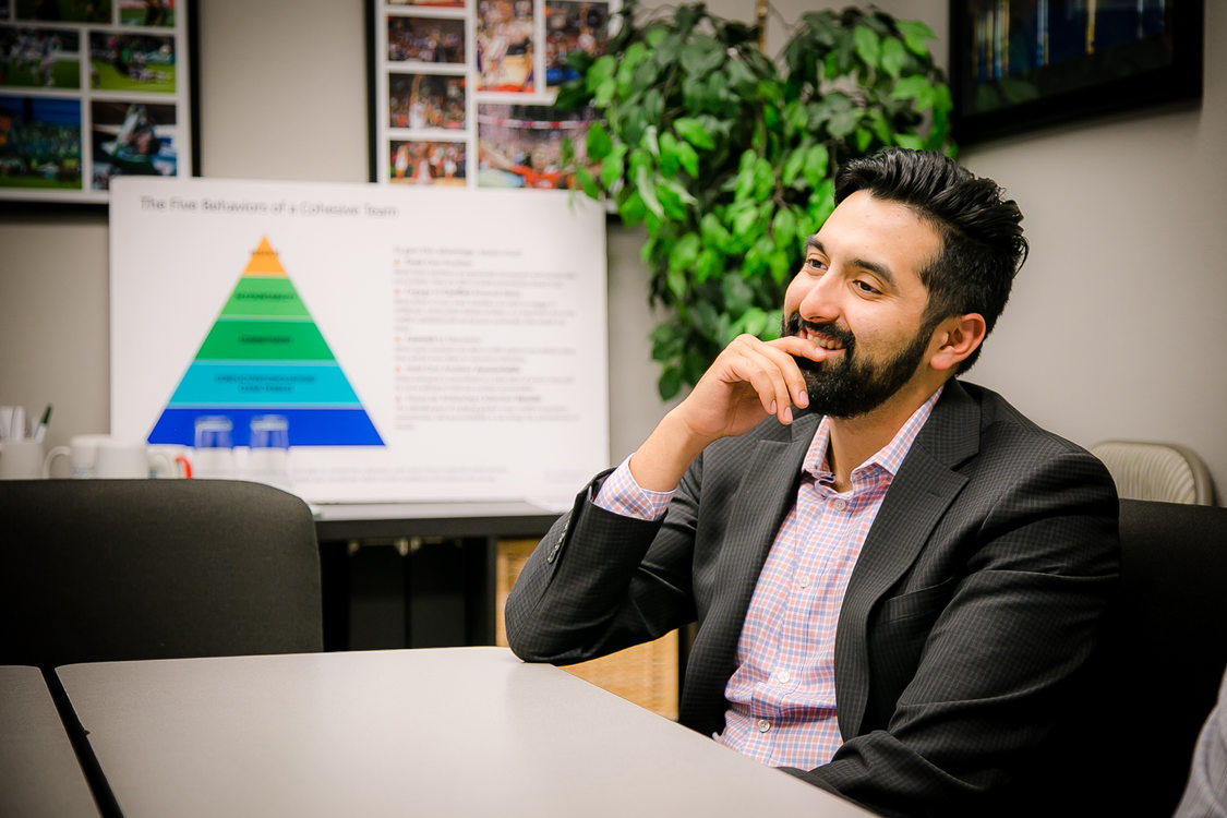 Metro Councilor Juan Carlos Gonzalez seated at a meeting table with a chart in the background