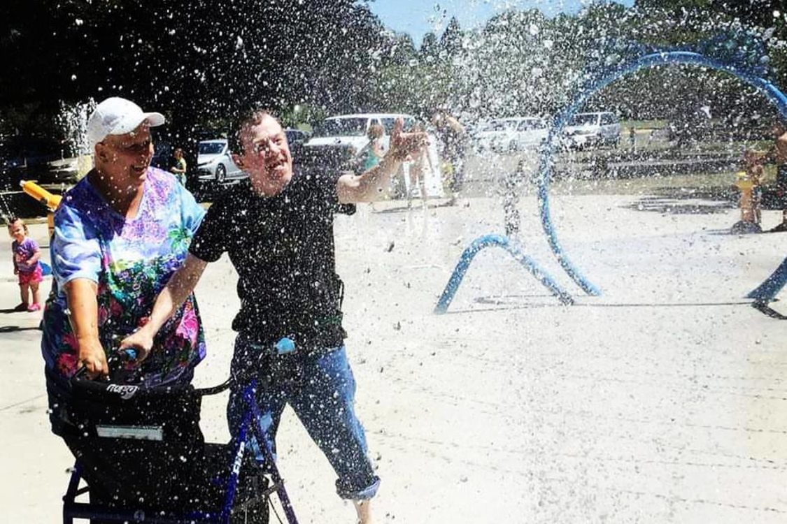 young man enjoying splash pad at park