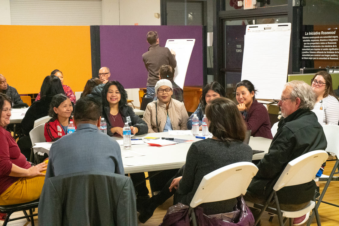 a group of people sit at a table to discuss important transportation issues in their community